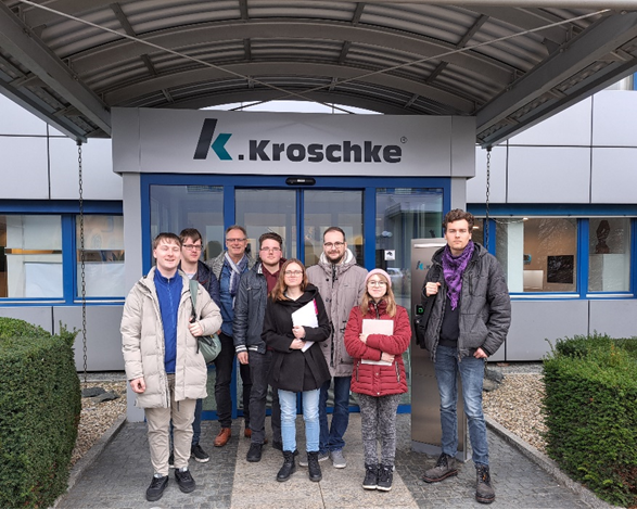 Auszubildende stehen vor der Eingangstür der Firma Kroschke
