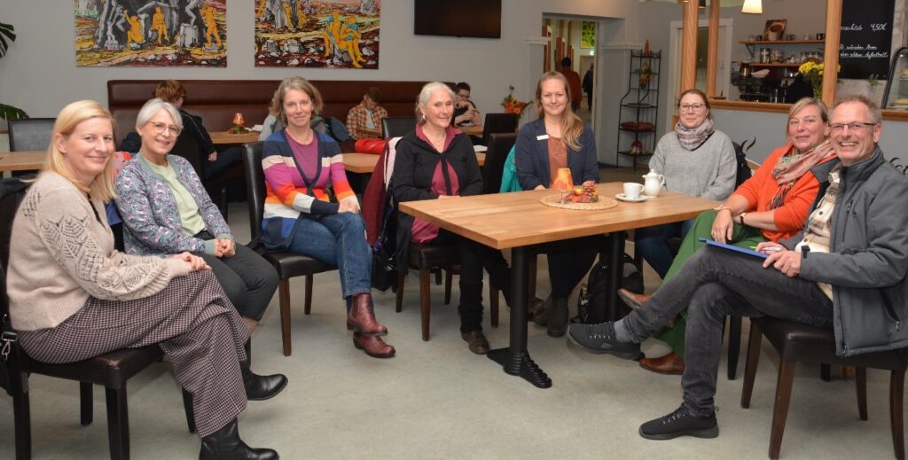 Eine Gruppe von Menschen sitzt im Halbkreis in der Cafeteria der Lavie Reha gGmbH